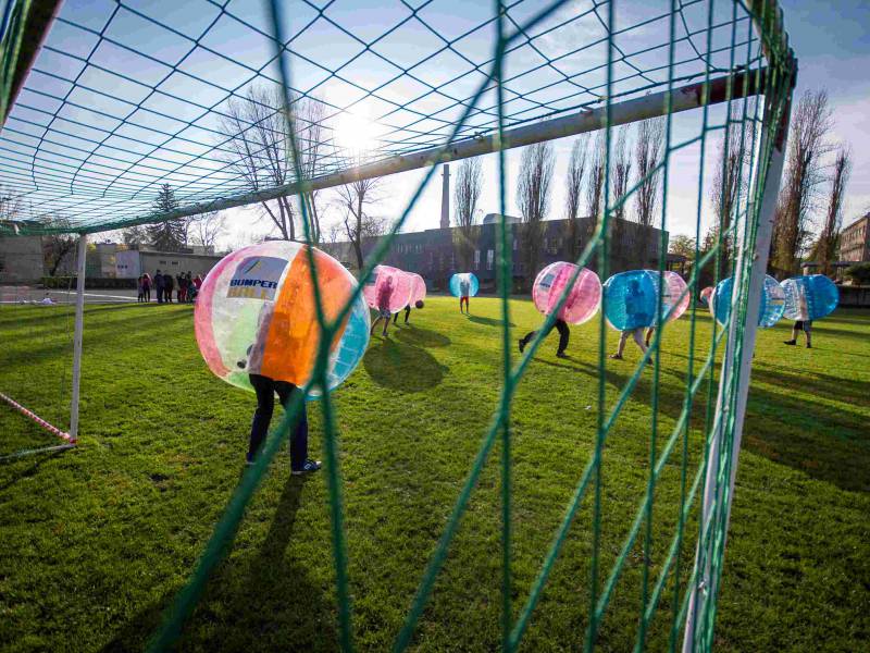 a picture of people playing football in bubble balls